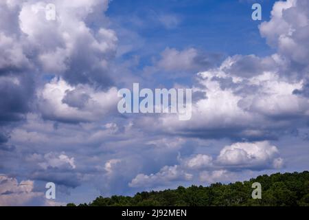 Dramatic fluffy cloudscape and deep blue sky Stock Photo