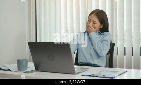 Young asian women yawning in the afternoon of working at the office. Stock Photo