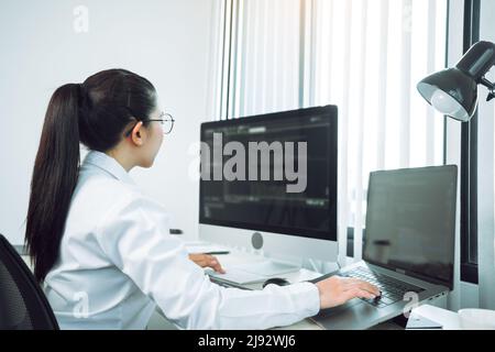 Asian woman professional development programming website working a software in office room. Stock Photo