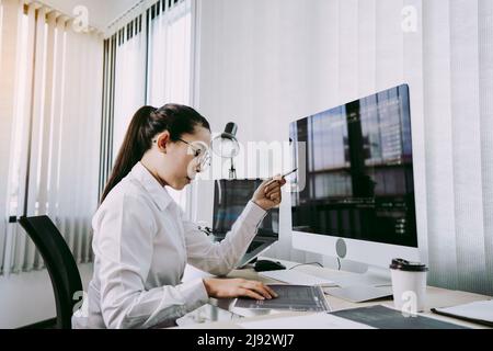 Asian woman professional development programming website working a software in office room. Stock Photo