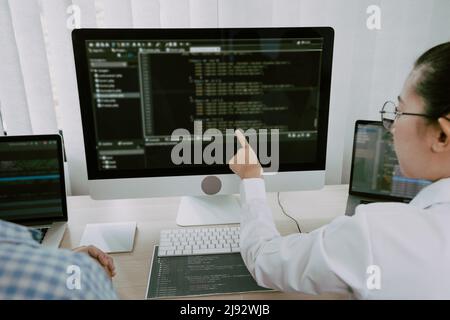 Two asian team working development of programming and encryption technology website design programmers on desk in office. Stock Photo