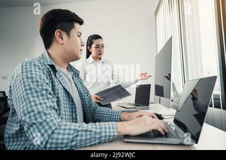 Two asian team working development of programming and encryption technology website design programmers on desk in office. Stock Photo