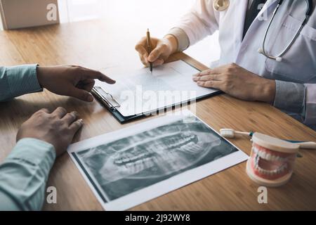 Dentists are discussing dental problems at report x-ray image for patients. Stock Photo