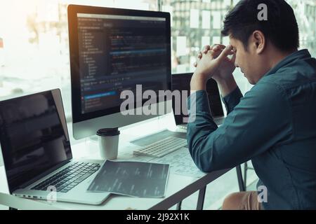 Software developers headache with code analysis in the office. Stock Photo