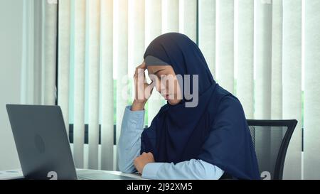Muslim women sit at work stress and headache. Stock Photo