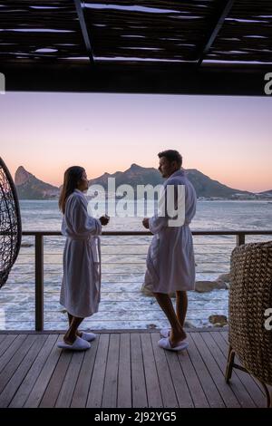 couple man and women drinking coffee during on balcony sunrise at vacation in Cape Town South Africa.  Stock Photo