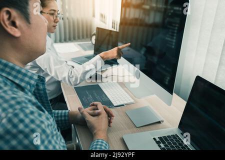 Two asian team working development of programming and encryption technology website design programmers on desk in office. Stock Photo