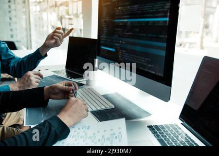 Two partnerships developing programming and coding technologies working on laptop and analyzing together. Stock Photo
