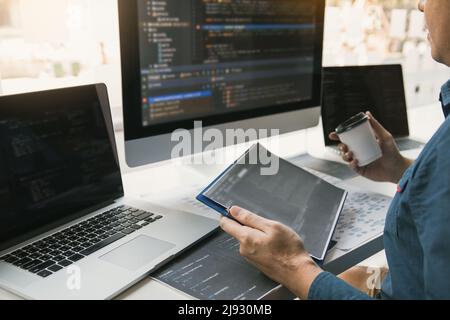 Working in the morning with businessmen are dipping coffee that works with software developers to analysis together the code written in the program on Stock Photo