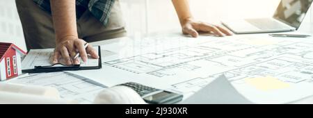 Engineers are designing working on blueprints and analyzing the structure of the project. Stock Photo