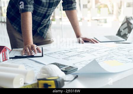 Engineers are designing working on blueprints and analyzing the structure of the project. Stock Photo