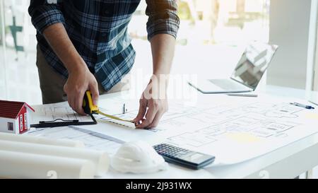 Architects are working on a new project while using a tape measure. Stock Photo