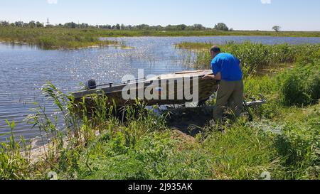 A man launches a motorboat Stock Photo - Alamy