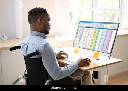 Medical Coding Spreadsheet On PC. African Man In Wheelchair Stock Photo