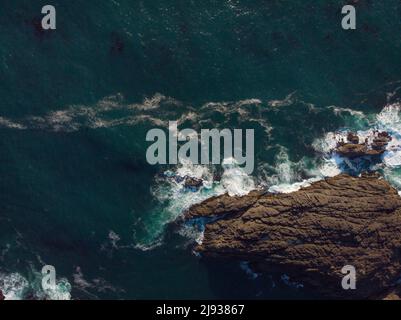 Shot from the air. Bright turquoise ocean water with white foamy waves and rocky shore. Calm. Beautiful majestic nature. There are no people in the ph Stock Photo