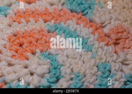 Close up abstract texture background of elegant crocheted fabric with blue, white and orange yarn Stock Photo