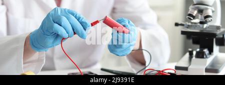 Master repairman checking battery charge using tester closeup Stock Photo