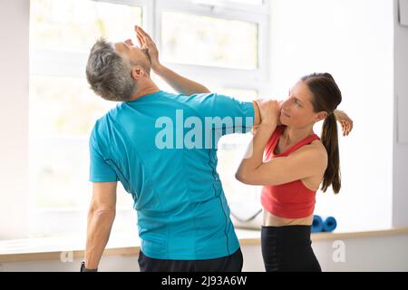 Male Personal Trainer Sparring With Female Boxer In Gym Using Training ...