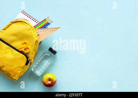 Yellow school backpack with colorful school stationery Stock Photo