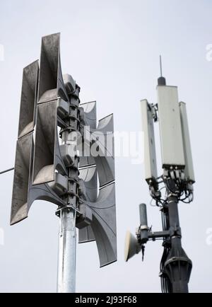 Teltow, Germany. 17th May, 2022. An alarm siren (l) is mounted on the roof of an apartment building owned by Wohnungsbaugesellschaft Teltow (WGT) next to mobile phone antennas. Credit: Soeren Stache/dpa/Alamy Live News Stock Photo