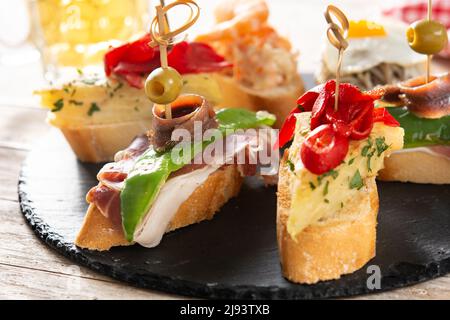 Assortment of Spanish pintxos on wooden table Stock Photo