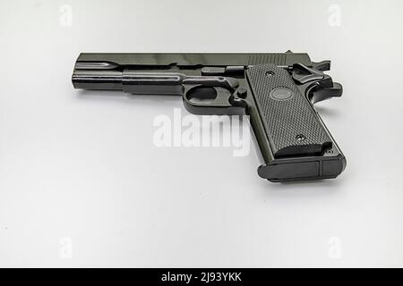 Black handgun flat on a white background. Copy Space. Stock Image. Stock Photo