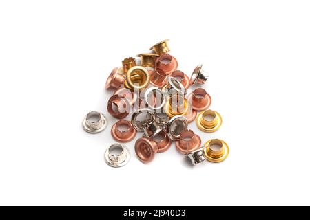 Eyelets in copper, gold and silver colored metal on a white background Stock Photo