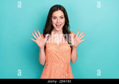 Photo of sweet impressed woman wear orange outfit empty space rising hands arms open mouth isolated turquoise color background Stock Photo