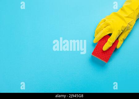 female hand in yellow rubber protective glove with micro fiber yellow rag for. washing dishes.  housewife takes care of the house. general or regular Stock Photo