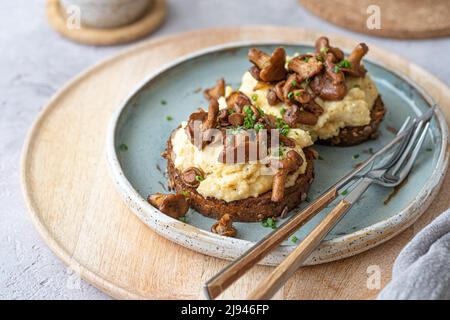 Cozy breakfast Scrambled eggs with chanterelle on buns with tea, copy space Stock Photo