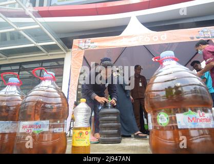 Jakarta, Indonesia. 20th May, 2022. A woman packages a tank of cooking oil at a market in Jakarta, Indonesia, May 20, 2022. Indonesia will lift an export ban on crude palm oil, cooking oil, refined, bleached and deodorized (RBD) palm oil, and RBD palm olein starting May 23, as the country has brought domestic cooking oil prices and supply under control. Credit: Zulkarnain/Xinhua/Alamy Live News Stock Photo