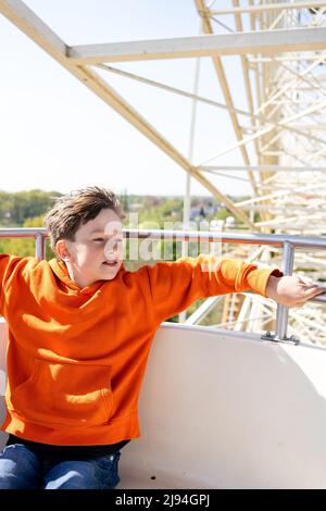 Boy on a ferris wheel in Slaghaven Park, Holland on sunny day Stock Photo
