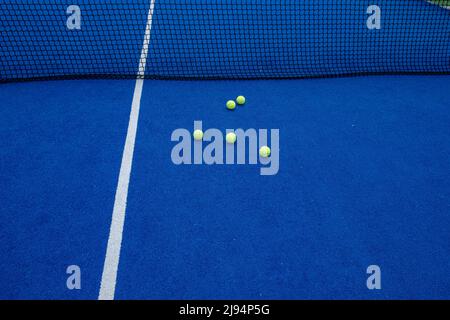 Balls on a blue artificial grass paddle tennis court Stock Photo