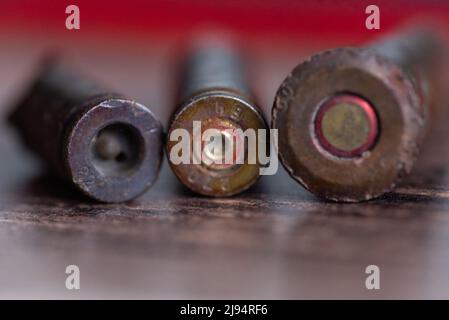 Three used shells lie on the table with caps to the foreground Stock Photo