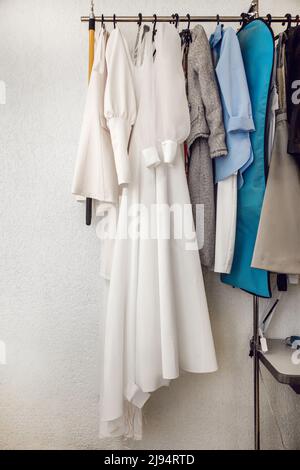 Female dresses on hangers in room Stock Photo - Alamy