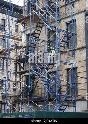 A construction worker rests on his scaffolding somewhere in Manhattan. Stock Photo