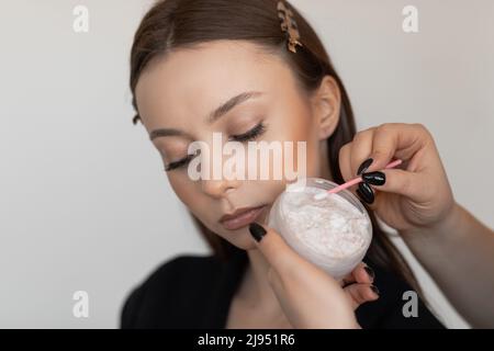 Woman face in spa salon laying and correcting and brushing eyebrows by brush with gel, checking brow eye line. Close up Stock Photo