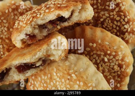 Date filled or stuffed pastry with sesame, close up on pastry with sesame known as 'kombe' in Hatay, Turkey. Stock Photo