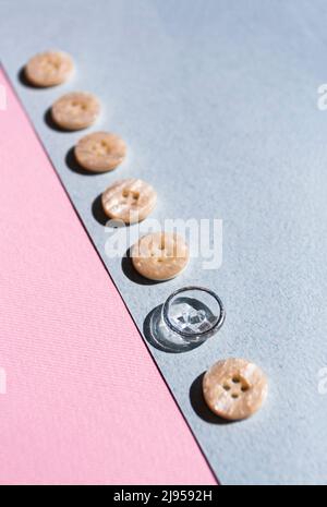 A row of buttons, one of them special, lies on a blue and pink background. Minimalist concept. Stock Photo