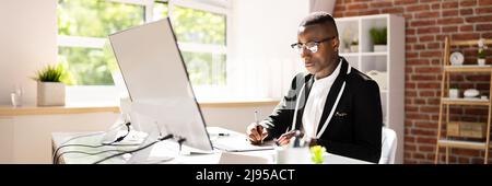 Young Male Designer Editing Photos On Computer In Office Stock Photo
