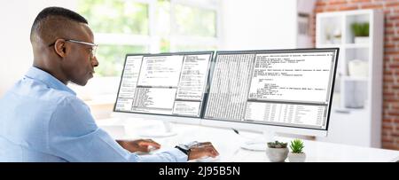 African American Coder Using Computer At Desk. Web Developer Stock Photo