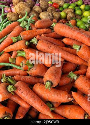 pile of fresh carrots and vegetables in a market Stock Photo