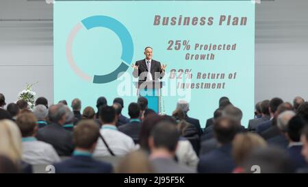 Businessman on a podium giving a speech at a business conference Stock Photo