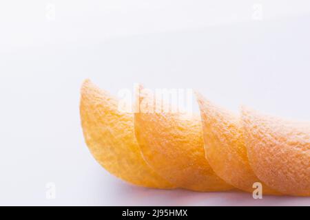 close up of stacked and fried potato chips on white background Stock Photo