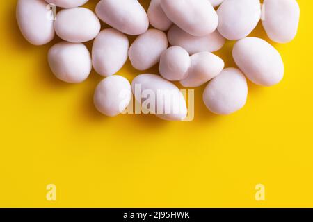 close up view of peeled pine nuts on yellow background Stock Photo