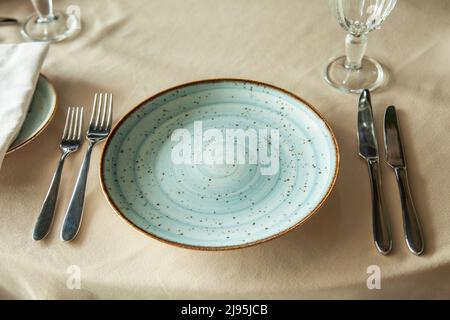 A beautiful plate on the table with forks and knives Stock Photo