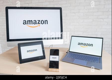 Amazon logo on computer screens, laptop digital tablet and smartphone. Applications for all devices online store where you can buy everything. Online Stock Photo