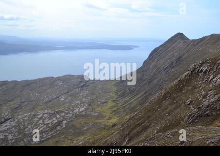 Looking west from the high ridge of Ben Mor Coigach with the opening of Loch Bloom ahead. Wild mountain and coastal scenery in NW Scotland Stock Photo