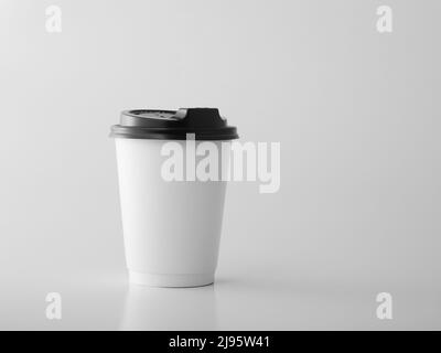 White takeaway paper cup with black plastic lid. Stock Photo