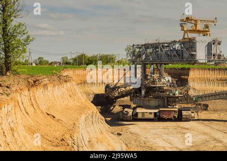 Industrial view of opencast mining quarry with machinery at work. Area has been mined for copper,silver, gold, and brown coal mine. Bucket-wheel excav Stock Photo